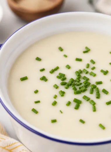 Easy French Vichyssoise recipe featuring chilled potato and leek soup garnished with chives.
