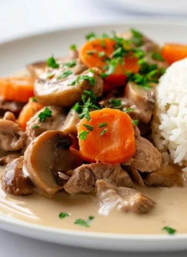 Creamy veal blanquette stew served in a bowl, garnished with fresh herbs