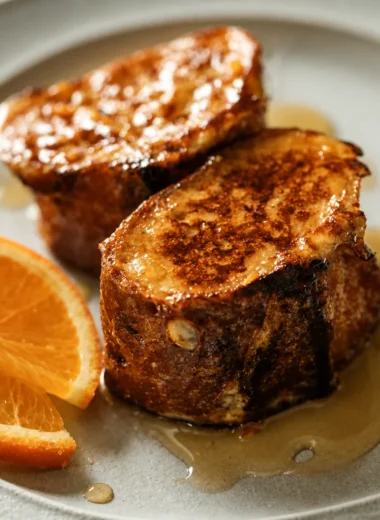 Deliciously Easy French Pain Perdu Recipe served with maple syrup on a plate.