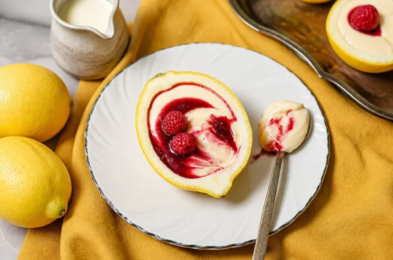 Lemon cream dessert topped with raspberry sauce on a white plate