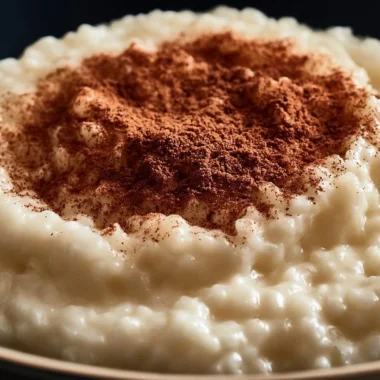 Delicious bowl of traditional riz au lait topped with cinnamon and served with a spoon