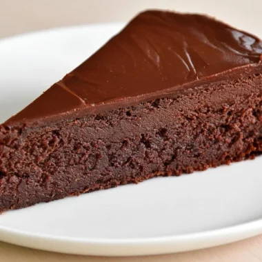 Slice of Traditional French Chocolate Cake (Gâteau au Chocolat) topped with cocoa dust