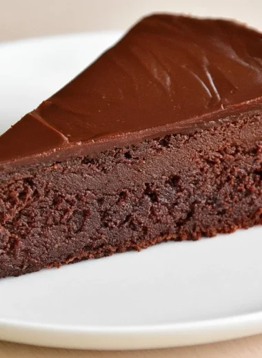 Slice of Traditional French Chocolate Cake (Gâteau au Chocolat) topped with cocoa dust